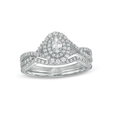 0.58 CT. T.W. Oval Diamond Double Frame Twist Shank Bridal Set in 10K White Gold (I/I2)