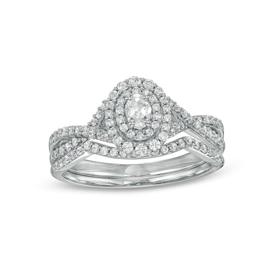 0.58 CT. T.W. Oval Diamond Double Frame Twist Shank Bridal Set in 10K White Gold (I/I2)
