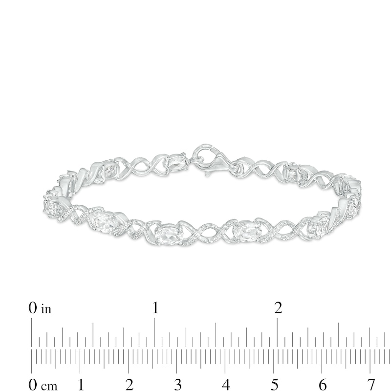 Main Image 4 of Oval White Lab-Created Sapphire and 0.18 CT. T.W. Diamond Infinity Ribbon Link Line Bracelet in Sterling Silver – 7.5"