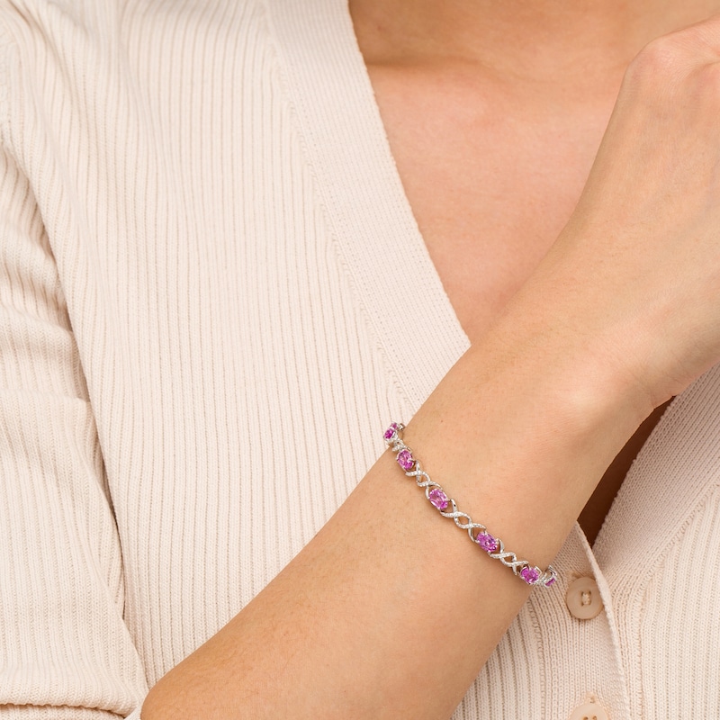 Main Image 2 of Oval Pink Lab-Created Sapphire and 0.18 CT. T.W. Diamond Infinity Ribbon Link Line Bracelet in Sterling Silver – 7.5"