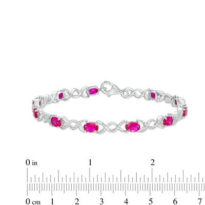 Oval Lab-Created Ruby and 0.18 CT. T.W. Diamond Infinity Ribbon Link Line Bracelet in Sterling Silver – 7.5"