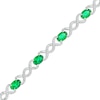 Thumbnail Image 1 of Oval Lab-Created Emerald and 0.18 CT. T.W. Diamond Infinity Ribbon Link Line Bracelet in Sterling Silver – 7.5"