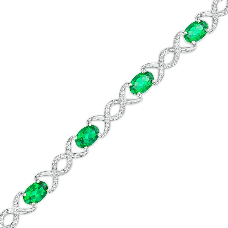 Main Image 1 of Oval Lab-Created Emerald and 0.18 CT. T.W. Diamond Infinity Ribbon Link Line Bracelet in Sterling Silver – 7.5"