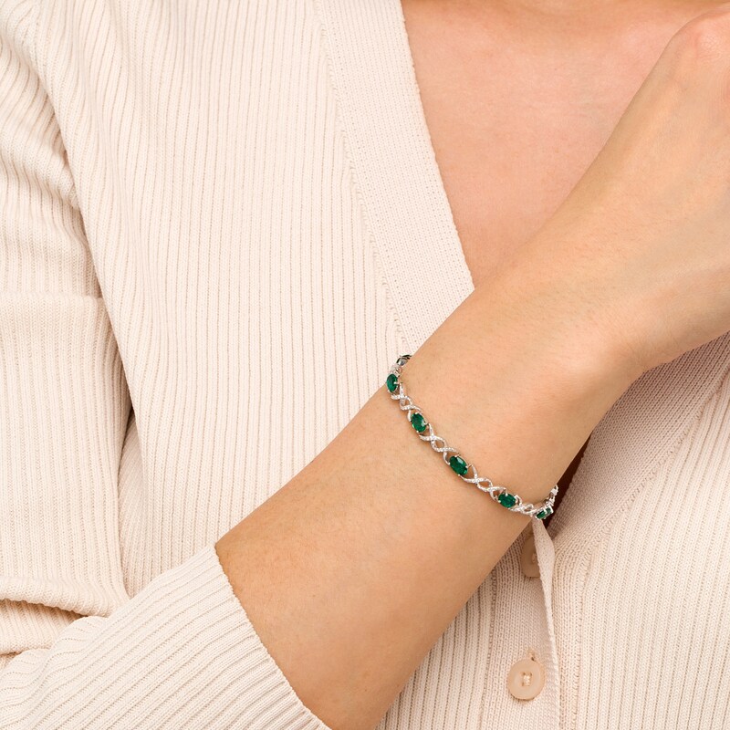 Main Image 2 of Oval Lab-Created Emerald and 0.18 CT. T.W. Diamond Infinity Ribbon Link Line Bracelet in Sterling Silver – 7.5"
