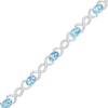 Thumbnail Image 1 of Oval Blue Topaz and 0.18 CT. T.W. Diamond Infinity Ribbon Link Line Bracelet in Sterling Silver – 7.5"
