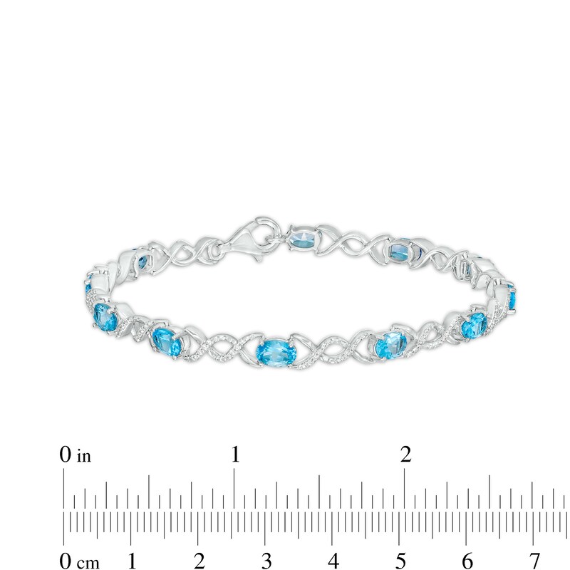 Main Image 4 of Oval Blue Topaz and 0.18 CT. T.W. Diamond Infinity Ribbon Link Line Bracelet in Sterling Silver – 7.5"