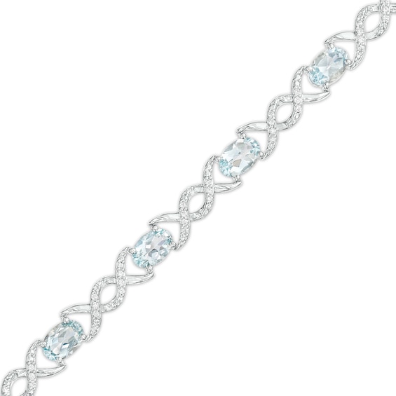 Oval Aquamarine and 0.18 CT. T.W. Diamond Infinity Ribbon Link Line Bracelet in Sterling Silver – 7.5"