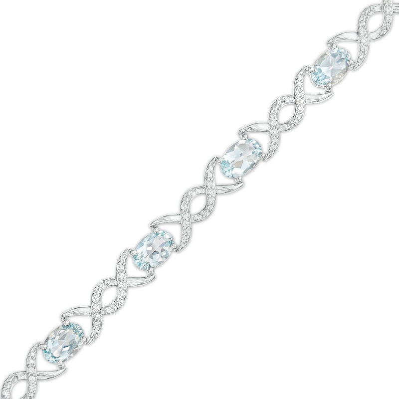 Oval Aquamarine and 0.18 CT. T.W. Diamond Infinity Ribbon Link Line Bracelet in Sterling Silver – 7.5"