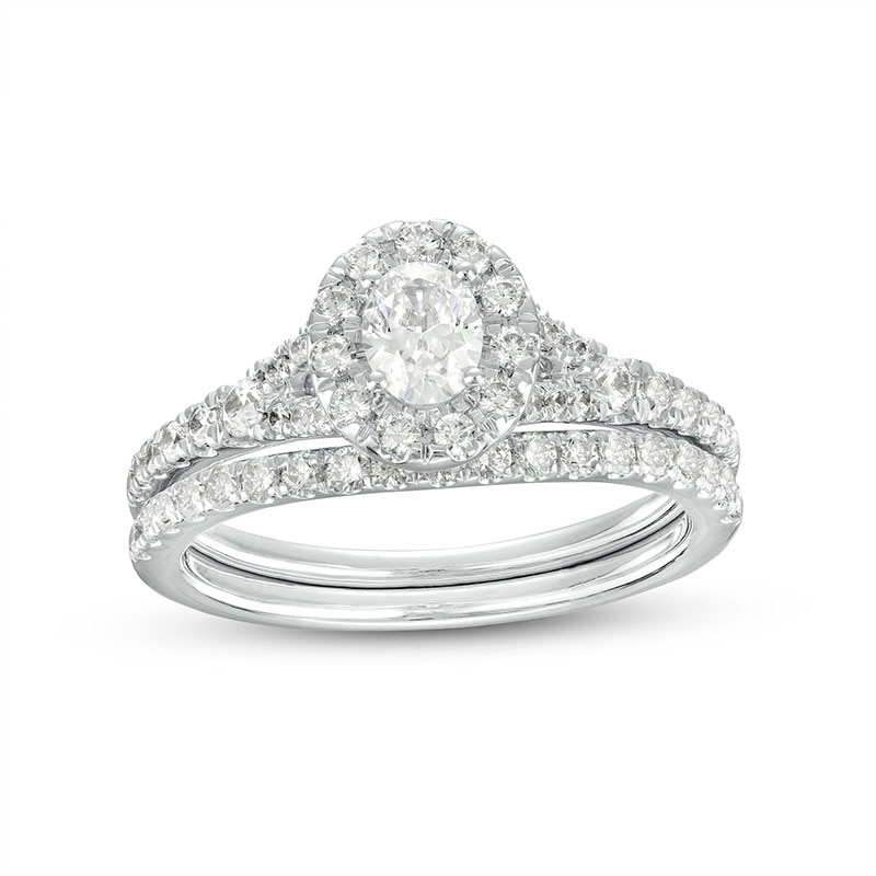 Previously Owned - 0.95 CT. T.W. Oval Diamond Frame Bridal Set in 14K White Gold (I/I1)