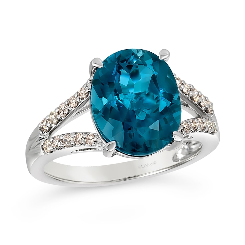 Previously Owned - Le Vian® Oval Deep Sea Blue Topaz™ and 0.28 CT. T.W. Nude Diamond™ Split Shank Ring in 14K Vanilla Gold®